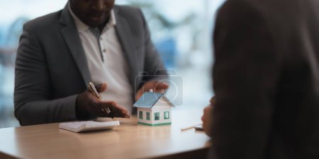 Téléchargez les photos : Agent immobilier afro-américain montrant la maison à ses clients après la signature du contrat, concept pour l'immobilier, déménagement ou location de biens avec diversité ethnique. - en image libre de droit
