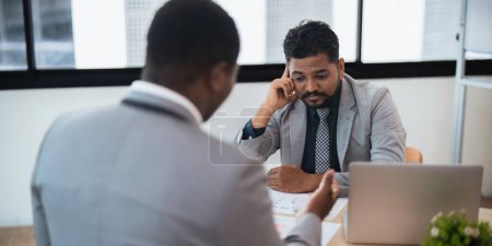 Téléchargez les photos : Les gens d'affaires indien et afro-américain travailleur qui cherchent à discuter de la stratégie d'entreprise dans le travail d'équipe, travailler sur ordinateur portable dans le bureau au bureau. - en image libre de droit