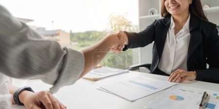 Foto de Dos mujeres de negocios seguras estrechando las manos durante una reunión en la oficina, el éxito, el trato, el saludo y el concepto de socio. - Imagen libre de derechos