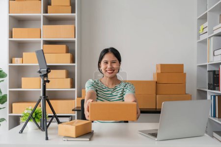 Téléchargez les photos : Startup petite entreprise entrepreneur ou femme asiatique tenant boîte de colis, Jeune succès femme asiatique avec sa boîte d'emballage de marketing en ligne et la livraison. - en image libre de droit