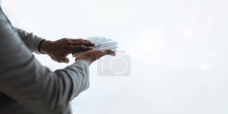 Photo for Businessperson rich man ethnicity diversity displaying a spread of cash over a green vintage background. - Royalty Free Image