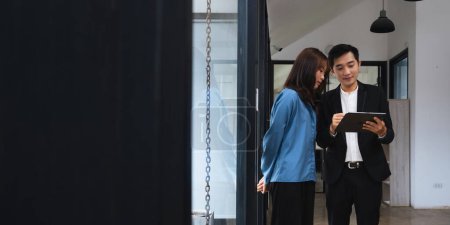 Téléchargez les photos : Deux travailleurs d'affaires asiatiques regardant tablette discuter de la stratégie d'entreprise dans le travail d'équipe. - en image libre de droit