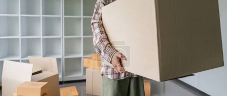 Foto de Día de mudanza. primer plano macho asiático mano llevar caja para mover de viejo a nuevo hogar o residencia. - Imagen libre de derechos