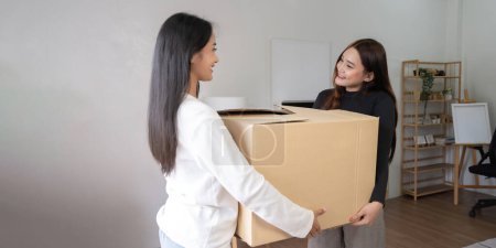Téléchargez les photos : Homosexuel heureux jeune asiatique femme et copine tout en portant leurs biens déménagement dans nouvelle maison de location. - en image libre de droit