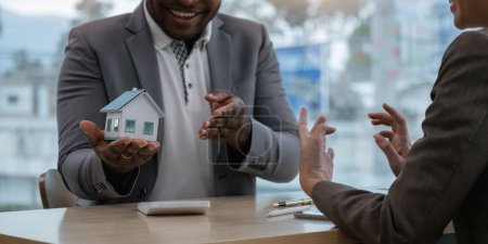 Photo for African American male real estate agent is having a discuss with his business woman asian client. security concept about house to client before sign contract. - Royalty Free Image
