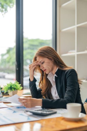 Foto de Negocios mujeres asiáticas son el estrés mientras se trabaja en el ordenador portátil, Mujer de negocios cansado con dolor de cabeza en la oficina, sentirse mal en el trabajo. - Imagen libre de derechos