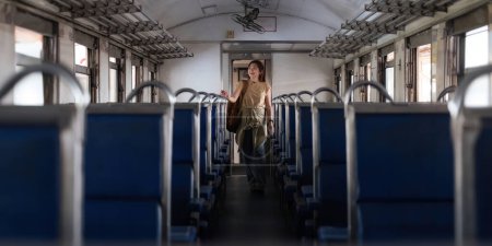 Téléchargez les photos : Femme asiatique jeune routard stand intérieur du train à la recherche de tourisme. concept transport style de vie voyage actif et aventure voyage. - en image libre de droit
