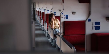 Foto de La joven viajera viaja en tren mientras está sentada dentro. turista viajero tienen pequeño viaje fuji como el concepto de fondo transporte estilo de vida activo viaje y viaje. - Imagen libre de derechos