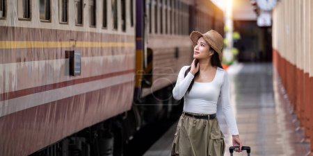 Photo for Alone Asian woman traveler with suitcase in walking train station platform. Summer vacation holiday and travel concept.. - Royalty Free Image