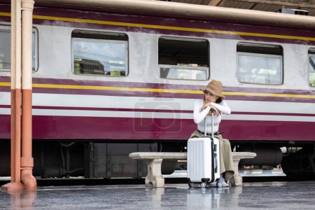 Téléchargez les photos : Seule voyageuse asiatique avec valise dans la plate-forme de la gare. Vacances d'été et concept de voyage.. - en image libre de droit