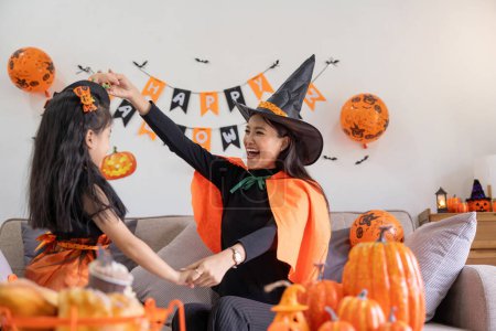 Photo for Happy family mother and child happy girl with Halloween at home together beautifully decorated. Mother teasingly playing with daughter. - Royalty Free Image