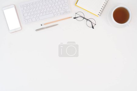 Photo for Top view above of white office desk table with keyboard notebook and coffee cup with equipment other office supplies. business and lifestyle concept with blank copy space. - Royalty Free Image