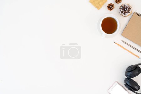 Photo for Top view above of white office desk with headphones, notebook and coffee cup with equipment other office supplies. business and finance concept with blank copy space. - Royalty Free Image