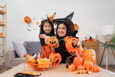 Foto de Feliz familia madre e hijo feliz niña con Halloween en casa juntos bellamente decorado. - Imagen libre de derechos