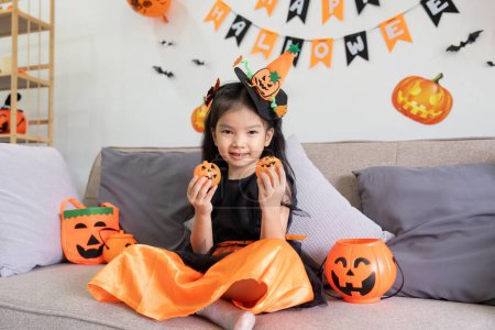 Téléchargez les photos : Petite fille mignonne avec ballon de citrouille. Bonne famille se préparant pour Halloween. - en image libre de droit