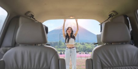 Photo for Young smiling woman park the car to store things to car before trip and smiling. - Royalty Free Image