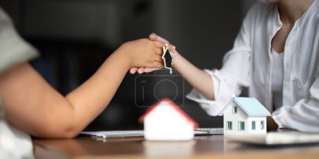 Téléchargez les photos : L'agent hypothécaire bancaire ou agent immobilier poignée de main avec l'affaire du client après la signature d'une assurance habitation, contrat de prêt. - en image libre de droit