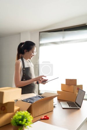 Photo for Startup SME small business entrepreneur of freelance Asian woman using laptop and box to receive and review order online to prepare to pack sell to customers, online sme business ideas. - Royalty Free Image