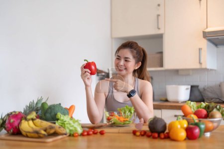 Photo for Young Asian healthy beautiful woman with casual clothes is smile and slicing fresh fruit to diet at home in kitchen in holiday. - Royalty Free Image