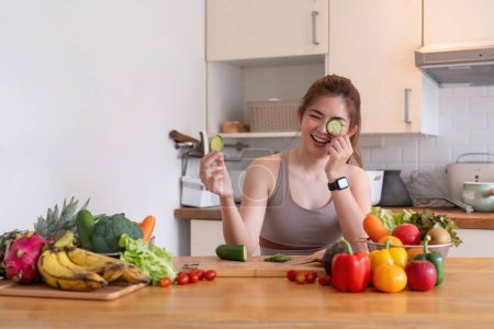 Photo for Young Asian healthy beautiful woman with casual clothes is smile and slicing fresh fruit to diet at home in kitchen in holiday. - Royalty Free Image