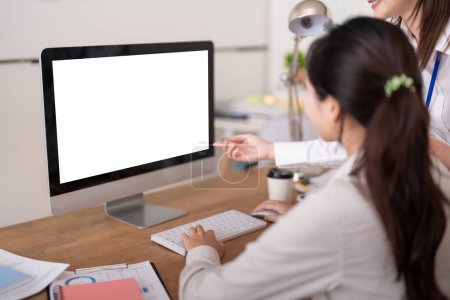Foto de La computadora se burla. Dos personas de negocios discuten en la oficina con la pantalla vacía blanca visible con espacio de copia. - Imagen libre de derechos