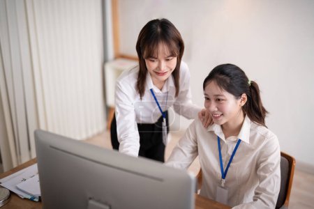 Téléchargez les photos : Employé de l'entreprise asiatique et collègue travaillent ensemble dans le bureau. en parlant et en donnant des conseils. - en image libre de droit