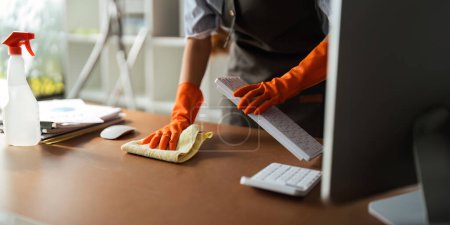 Photo for Asian woman cleaning in work room at home. Young woman housekeeper cleaner use a cloth to wipe equipment for working. concept housekeeping housework cleaning. - Royalty Free Image