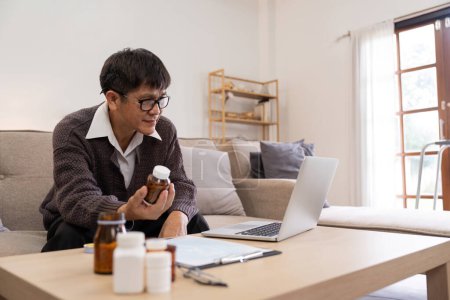 Téléchargez les photos : Asiatique Mature homme adulte ayant appel vidéo consultation avec médecin médecine sur ordinateur portable à partir de la maison, la télésanté ou la télémédecine concept. - en image libre de droit