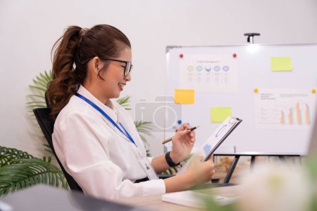 Photo for Asian businesswoman working on financial and accounting document on office desk. - Royalty Free Image