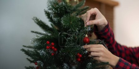 Téléchargez les photos : Femme décorer l'arbre de Noël. Ambiance de Noël à l'intérieur confortable maison. - en image libre de droit