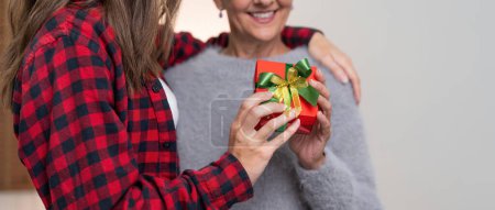 Téléchargez les photos : Joyeux Noël mère avec adulte fille échange cadeau maison. - en image libre de droit