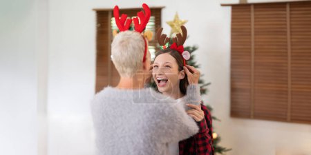 Photo for Mother and grown up daughter sitting in living room decorate on Christmas enjoying talk to each other. Christmas and New Year concept. - Royalty Free Image