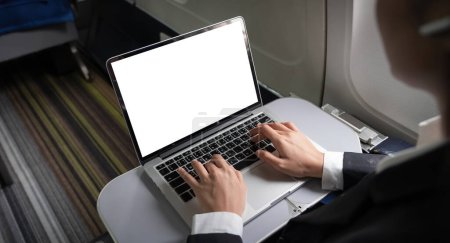 Photo for Business woman plane passenger using mock up laptop on board for working while sitting in airplane. Traveling and technology concept. - Royalty Free Image
