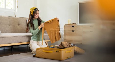 Photo for Beauty asian traveler woman packing prepare stuff and outfit clothes in suitcase travel bag luggage for holidays at home, weekend, tourist, journey. - Royalty Free Image