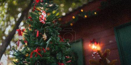 Foto de Fondo Árbol de Navidad y caja de regalo con decoraciones al aire libre cerca de una chimenea con luces. - Imagen libre de derechos