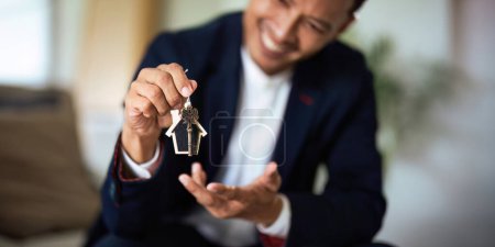 Téléchargez les photos : Les agents immobiliers acceptent d'acheter une maison et de donner les clés aux clients au bureau. Accord conceptuel. - en image libre de droit