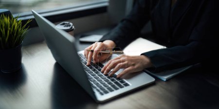 Foto de Close up Mujer de negocios asiática utilizando el ordenador portátil para calcular los datos fiscales y financieros de las empresas en la oficina. - Imagen libre de derechos