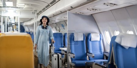 Foto de Turista joven con una maleta en el avión con una maleta en el avión. - Imagen libre de derechos