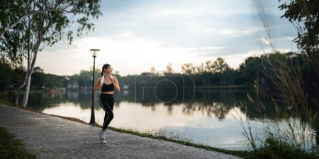 Photo for Jogging woman running in park on beautiful day off. Sport fitness model of asian ethnicity training outdoor for marathon. - Royalty Free Image