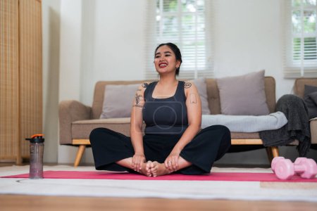 Photo for Asian overweight woman doing stretching exercise at home on fitness, Stretching training workout on yoga mat at home for good health and body shape. - Royalty Free Image