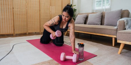 Photo for Happy fat overweight woman wearing sportswear doing fit exercise with dumbbells in living room at home. Workout sport, fitness and body concept. - Royalty Free Image