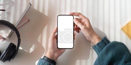 Photo for Top view mockup image of a woman holding mobile phone with blank white screen while sitting. - Royalty Free Image