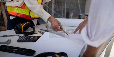 Photo for Construction concept of Engineer or architect meeting for project working with partner and engineering tools on building and blueprint in working site. - Royalty Free Image