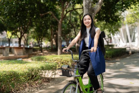 Asiatische Geschäftsfrau mit dem Fahrrad zur Arbeit im Büro. Fahrradpendler, glückliche Geschäftsfrau mit Ökotransport, Konzept des Öko-Lebensstils.