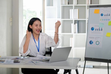 Photo for Happy excited business woman in office working with computer make winner gesture. excited success business asian woman triumph in office. - Royalty Free Image