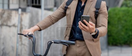 Geschäftsmann mit Fahrrad und Smartphone. Männer, die mit dem Fahrrad zur Arbeit fahren. Umweltfreundliches Fahrzeug, nachhaltiges Lifestylekonzept.