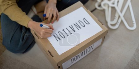 Photo for Woman asian preparing a delivery box with her used clothes, Donation and recycling concept. - Royalty Free Image