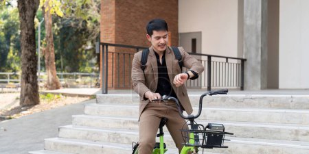 Hombre de negocios asiático en un traje está montando una bicicleta en las calles de la ciudad para su viaje de la mañana al trabajo. Concepto de transporte ecológico, concepto de estilo de vida sostenible.