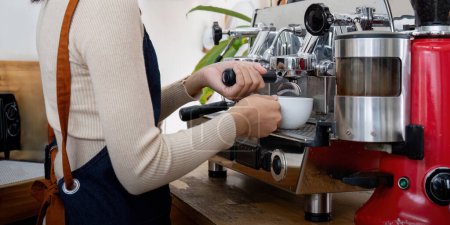 Foto de Mujer Barista utilizando máquina de café para hacer café en la cafetería
. - Imagen libre de derechos
