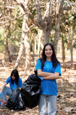 Photo for Volunteer collecting plastic trash in the forest. The concept of environmental conservation. Global environmental pollution. Cleaning the forest. - Royalty Free Image